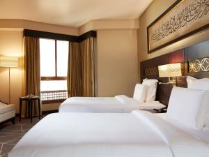 a hotel room with two beds and a window at Zamzam Pullman Madina in Al Madinah +142 photos