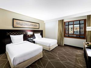 a hotel room with two beds and a window at Zamzam Pullman Madina in Al Madinah +152 photos