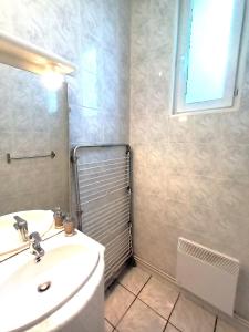 a bathroom with a sink and a toilet and a mirror at La Cour Palissy in Tours