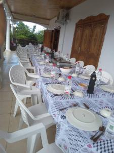 a long table with white chairs and plates on it at Océan Voyages Mitsamihouli in Mitsamiouli