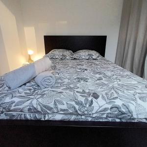 a bed with a black and white comforter and pillows at La Cour Palissy in Tours