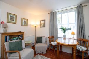 a living room with a table and chairs and a window at Wansfell View, Central Hawkshead with Hot Tub in Hawkshead