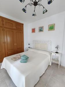 a bedroom with a white bed and a chandelier at The Brushstroke Of Mágina in Bedmar