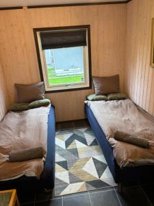 two beds sitting in a room with a window at Rimlige rom-kortidsleie 