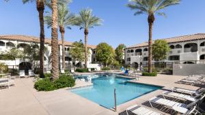 a pool with chairs and palm trees in a courtyard at Holiday Inn Club Vacations Scottsdale Resort in Scottsdale