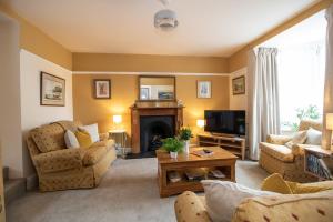 a living room with a couch and a fireplace at Wansfell View, Central Hawkshead with Hot Tub in Hawkshead