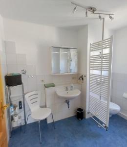 a white bathroom with a sink and a toilet at Ferienwohnung Lindeneck in Neusitz