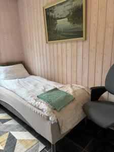 a bed in a room with a chair and a picture at Rimlige rom-kortidsleie  +8 photos