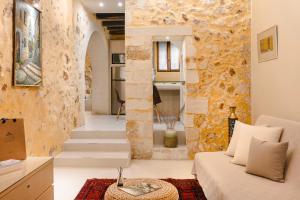 a living room with a couch and a stone wall at Alcanea Boutique Hotel in Chania Town +122 photos