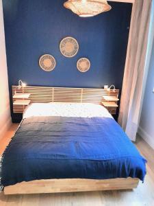a bedroom with a bed with a blue wall at Appartement Hyper centre refait à neuf in Luchon