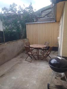 a patio with a table and chairs and a grill at Appartement Hyper centre refait à neuf in Luchon