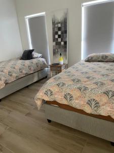 a bedroom with two beds and a wooden floor at Sunny Side Haven in Faure