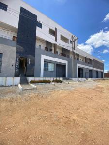 een groot gebouw met een zandveld ervoor bij Hotel Imperial in Santa Cruz