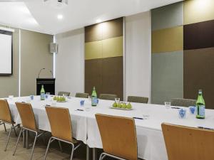 a conference room with a large white table and chairs at The Sebel Maroochydore in Maroochydore