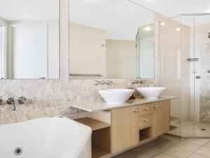 a bathroom with two sinks and a shower at The Sebel Maroochydore in Maroochydore