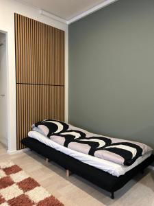 a bedroom with a bed with a black and white blanket at Beautiful two-room apartment with balcony in a prime location in Turku