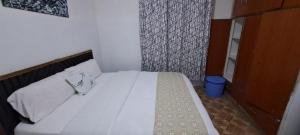 a bedroom with a white bed with a wooden headboard at Joy's One Bedroom Apartment in Kitale