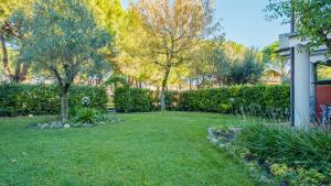 a yard with green grass and trees and bushes at Il Giardino Segreto - Italian Homing in Rivoltella