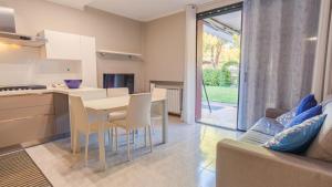 a kitchen and living room with a table and chairs at Il Giardino Segreto - Italian Homing in Rivoltella