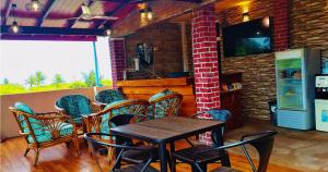 a dining room with a table and chairs and a television at White Sand Inn in Maamigili