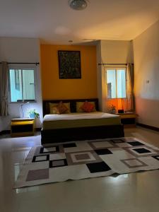 a bedroom with a large bed and a rug at Ao-Nang Private Yellow House 9 in Ao Nang Beach