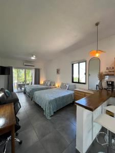 a bedroom with a bed and a desk and a kitchen at Casa Punta Perula VILLAS in Pérula