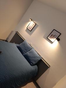 a bedroom with a bed and two pictures on the wall at LE NEW FLORIMONT in Chaumont