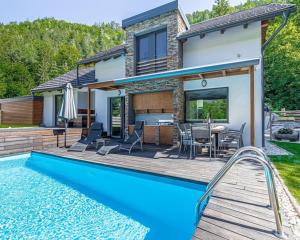a house with a swimming pool and a patio at Cassa Midas by the forest in Zgornje Jezersko