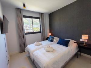 a bedroom with a large white bed with blue pillows at Higueron 5821 luxe appartement met zeezicht in Fuengirola +29 photos