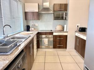een keuken met houten kasten en een spoelbak bij 105 Gouriqua Mosselbay in Mosselbaai +3 foto's