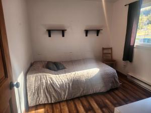 a bedroom with a bed with two pillows on it at Maison au Pied du Mont Video in Barraute