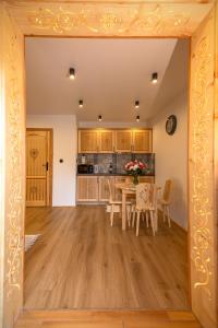 a kitchen and dining room with a table and chairs at Apartament Pod Magurą in Witów
