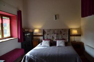 un dormitorio con una cama con dos almohadas en Chambre d'hôtes La Framboisine, en Bourgvilain