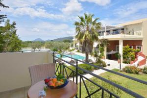 a balcony of a house with a bowl of fruit on a table at Likithos Village in Agios Georgios