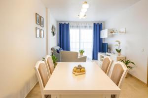 a dining room with a white table and chairs at Apartment las sirenas -WiFi 100 Mb-, Sea view in Roquetas de Mar