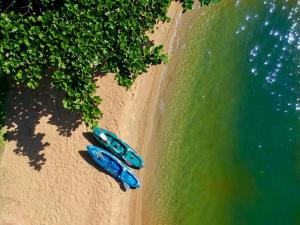two boats on a beach next to the water at Villa Colosseum in Florianópolis