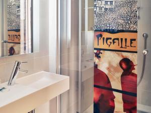 ein Badezimmer mit Waschbecken und Duschvorhang in der Unterkunft Mercure Paris Pigalle Sacre Coeur in Paris + 90 Fotos