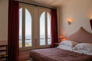 a bedroom with a bed and large windows at Il Capri Hotel in Capri