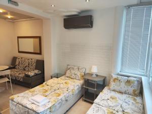 a room with two beds and a tv on the wall at Стаи за гости Ве-Бо-Ли** in Bankya