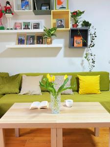 a living room with a green couch and a table at Oneone eleven hostel in Belgrade