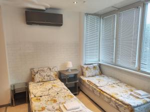 a room with a couch and a bed and windows at Стаи за гости Ве-Бо-Ли** in Bankya