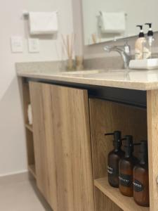 a bathroom counter with a sink and bottles of soap at Soneto 603 in Guadalajara