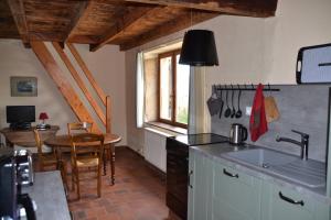 a kitchen with a sink and a table in a room at Gîte la Framboisine in Bourgvilain