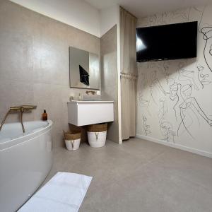 La salle de bains est pourvue de toilettes et d'une télévision murale. dans l'établissement La Plage maison de plage à Port Leucate, à Port-Leucate 36 autres photos