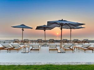 a group of chairs and umbrellas on the beach at Veranda Resort Pattaya - MGallery Collection, Accor Hotel in Jomtien Beach