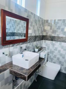 a bathroom with a sink and a toilet at White N Villa in Wadduwa