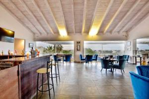 a restaurant with tables and chairs and a bar at Likithos Village in Agios Georgios