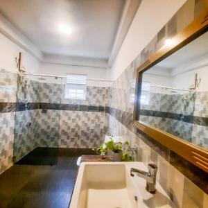 a bathroom with a sink and a mirror at White N Villa in Wadduwa