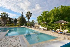 a large swimming pool with chairs and umbrellas at Likithos Village in Agios Georgios