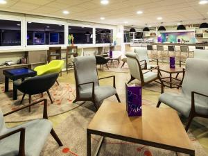 a waiting area with chairs and tables in a store at Novotel Santos Gonzaga in Santos